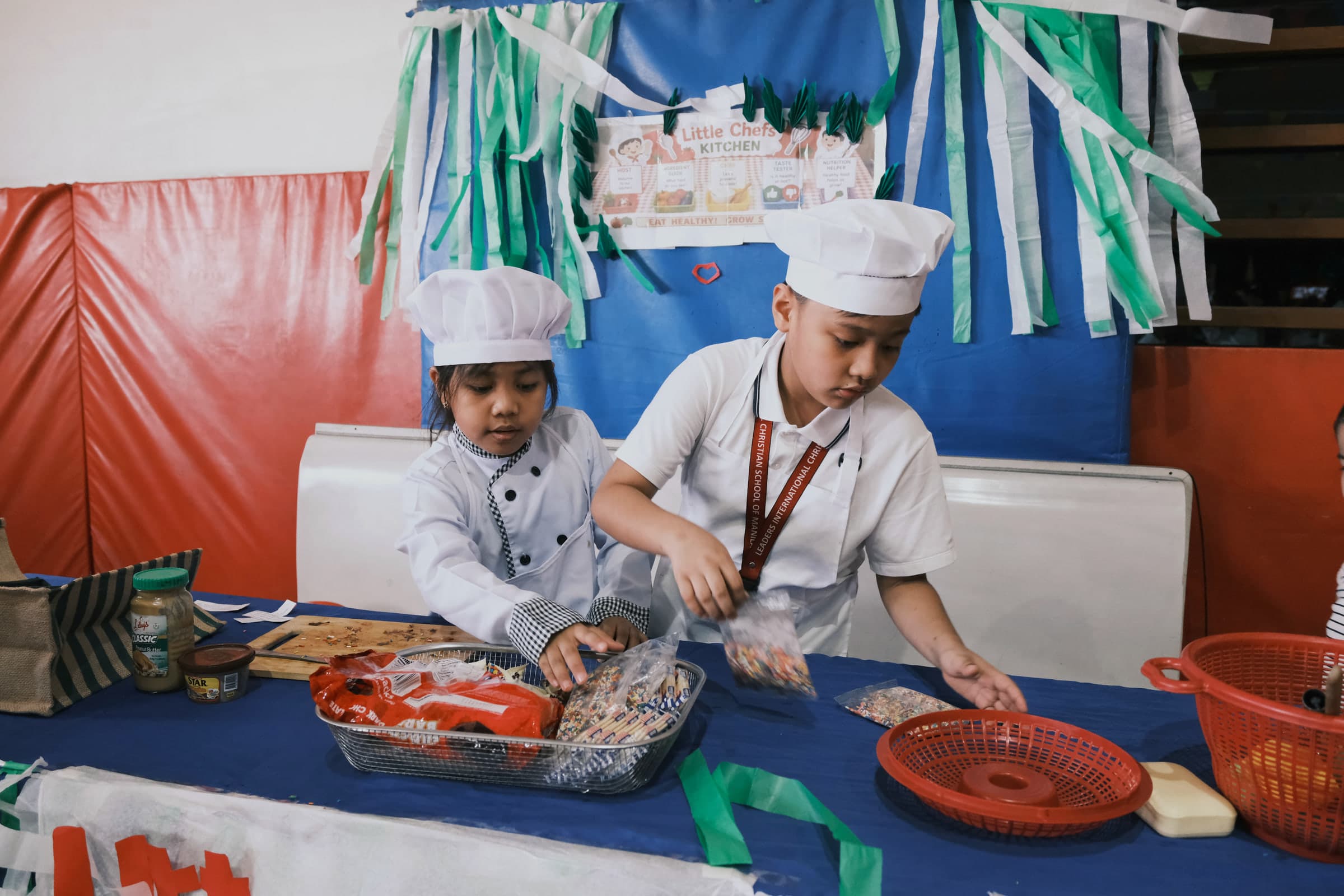 Two children at Leaders taking part in a hands-on Little Chefs learning activity.