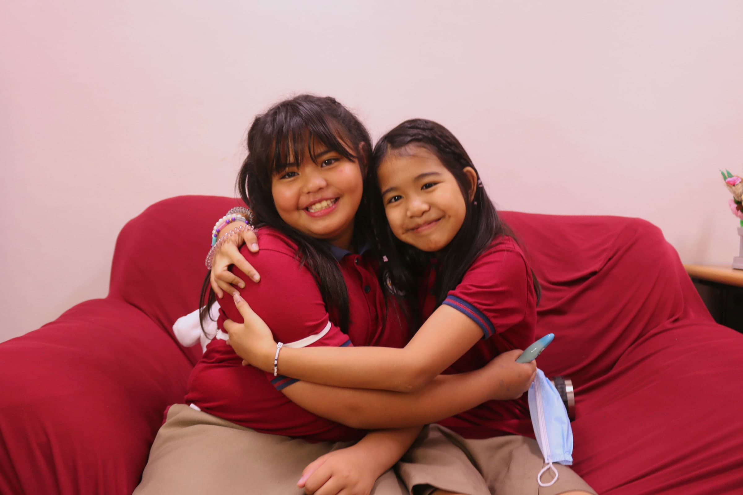 Two students at Leaders sharing a warm moment of friendship.