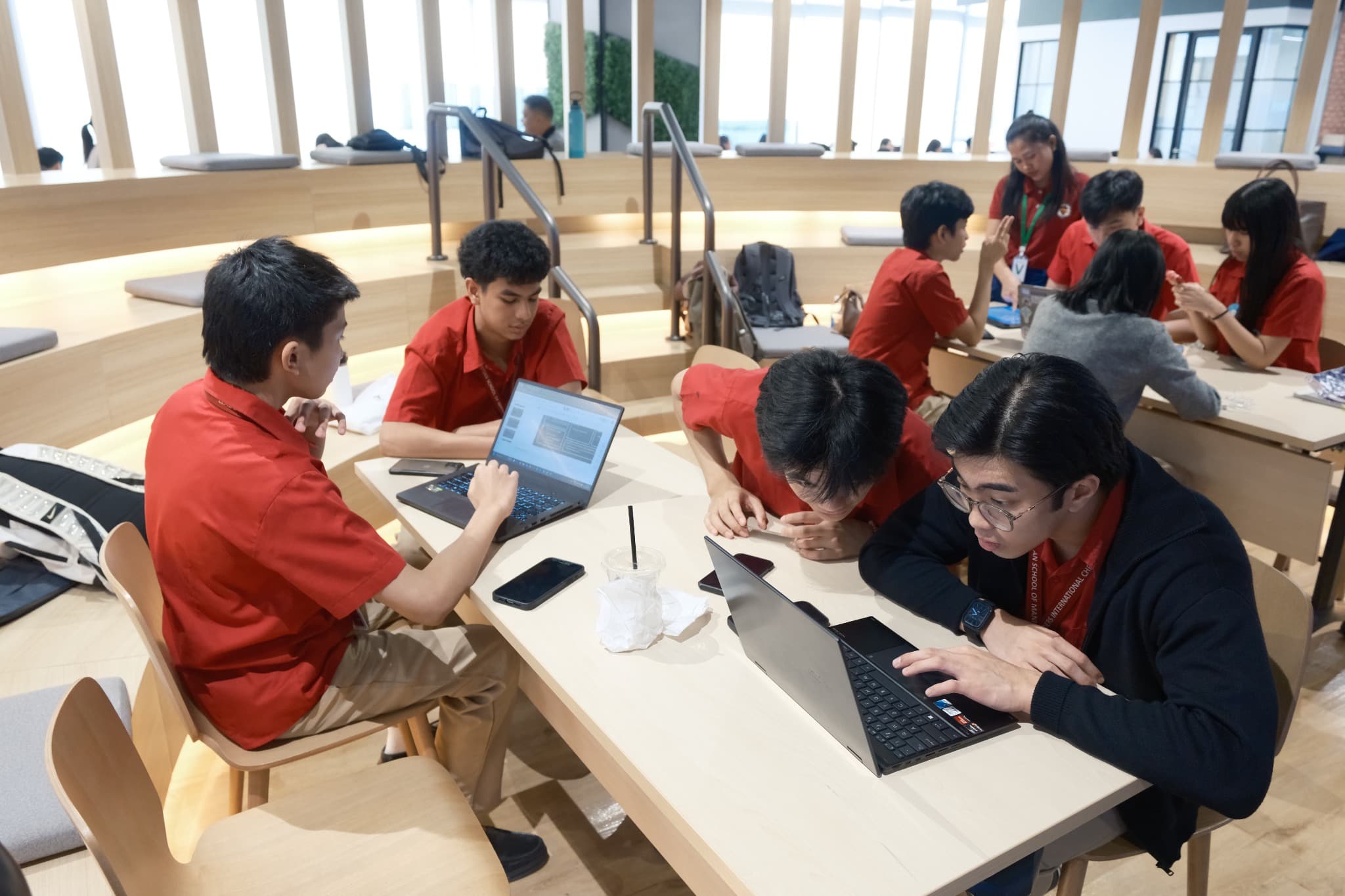 LICSM students collaborating with laptops during a digital learning activity.