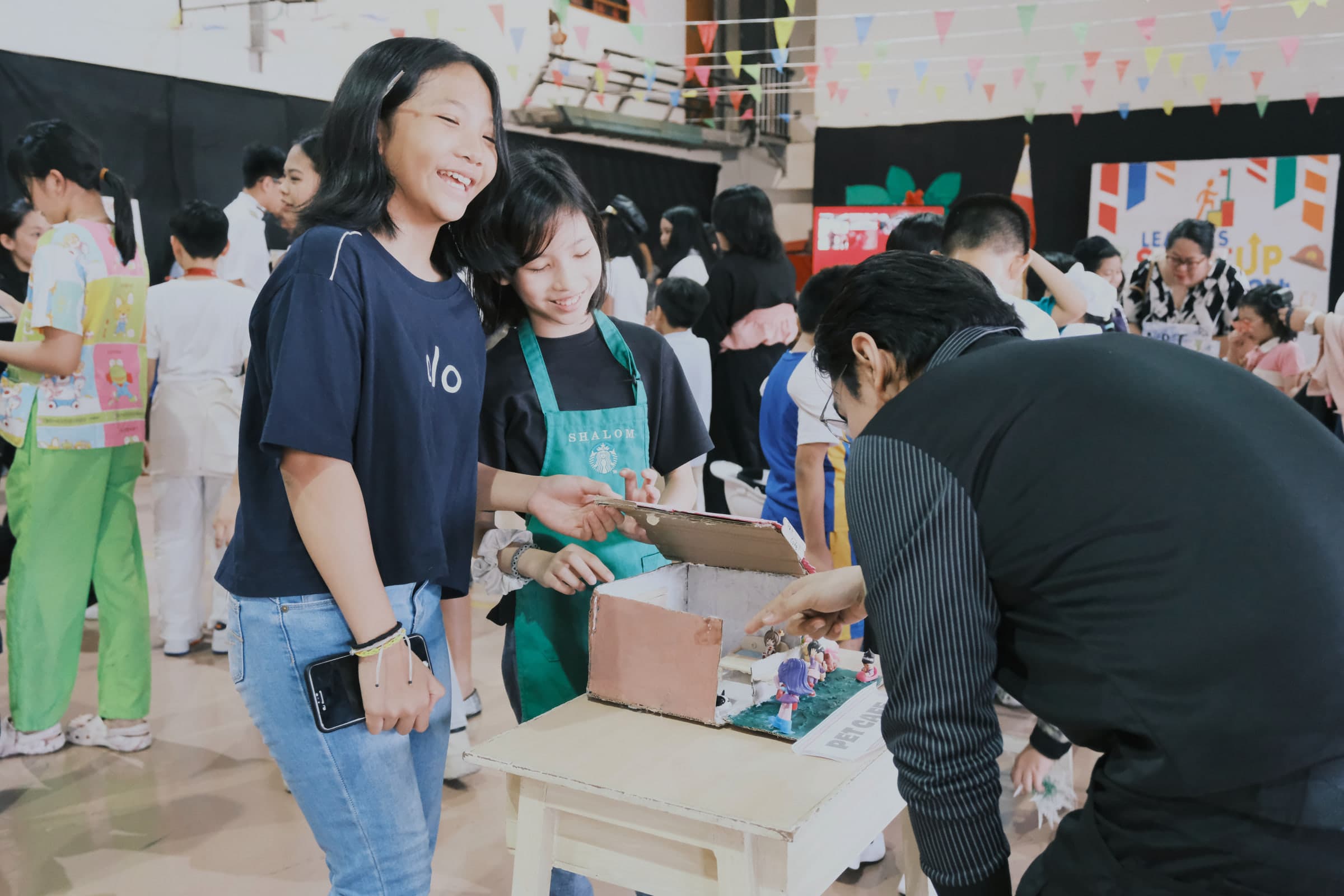 Students and families sharing a creative project during a school activity.