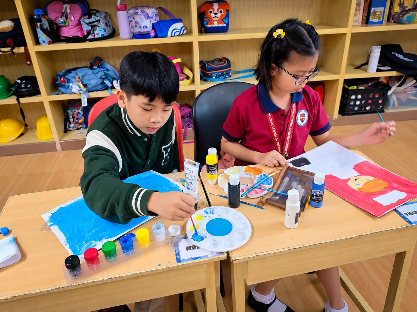 Elementary students painting together during an art class at Leaders.