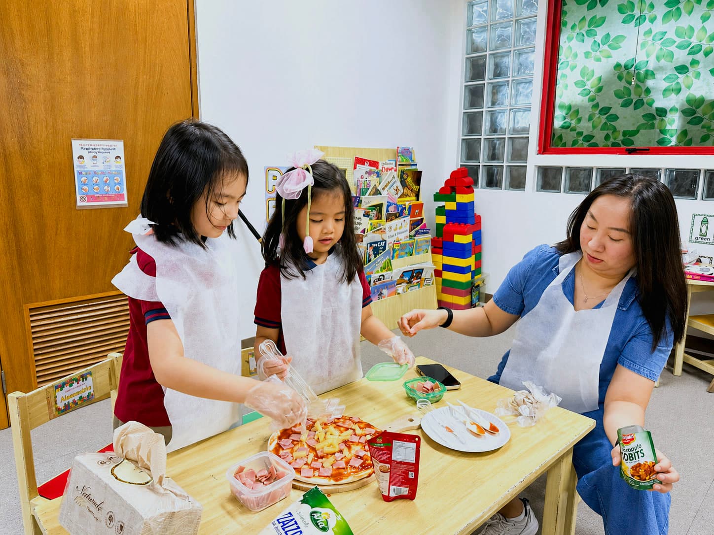 A teacher guiding preschool students through a hands-on food preparation activity.