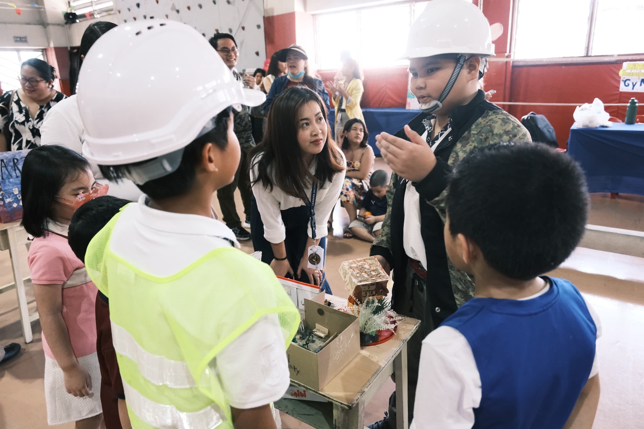 LICSM students explaining a hands-on project to younger learners.